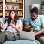 A couple at home stressfully reviewing household bills.