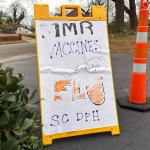 A sign advertising MMR and flu vaccines in a parking lot next to an orange pylon in South Carolina where outbreak response leaders have been trying to encourage the public to get vaccinated during a measles outbreak.