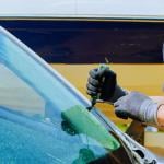 A technician replaces a damaged windshield at a car service center.