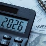 '2026' on a calculator over tax forms.