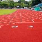A red running track in an athletic stadium.
