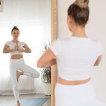 Young woman doing yoga at home in front of a mirror.