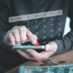A person using a smartphone to check a virtual calendar.
