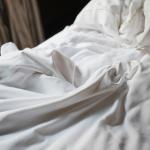 Soft white bedding on a cozy bed.