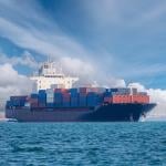 A cargo ship on open blue sea.