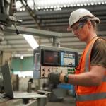 An industrial engineer working inside a manufacturing factory.