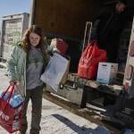 Leah Sheehy, a volunteer with Community Aid Network MN, moves donations from a truck parked in the snow in Minneapolis, Minnesota, on 2 February.