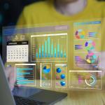 Set of business intelligence dashboard graphics over a person working on a laptop.