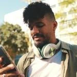 A young man checking phone outdoors.
