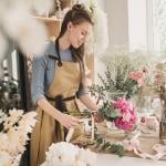 A female small business owner arranging flowers in her shop.