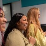 Three young women enjoying a lighthearted moment together in a restroom.