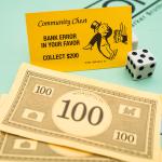 Banknotes and a bank error card from the Monopoly board game.