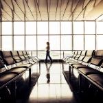 Woman waiting by the departure gate area in an airport.