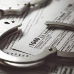 Handcuffs over U.S. tax 1040 forms.
