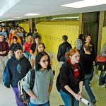 High school students walking along hallways.