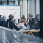 A business team inside a conference room discussing reports.