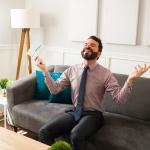 A businessman feeling free and happy while holding financial document.