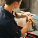 Woman at home trying on jewelry.