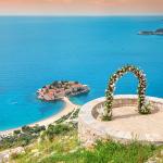 A romantic wedding ceremony at Montenegro Sveti Stefan viewpoint, with an arch adorned in flowers overlooking the Adriatic Sea.