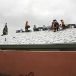 A construction team replacing a home's roof.