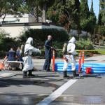Hazardous materials team cleaning up a truck and chemicals accident on the road.