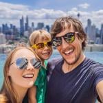 A family taking a selfie together with a view of a pool and city sky line.