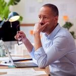 A businessman in deep thought while working in an office.