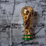 A miniature golden FIFA World Cup trophy on top of a map focused on Kansas City where the 2026 games will be held.