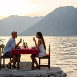 A young couple enjoying a romantic dinner by the beach.