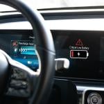 An electric vehicle's dashboard displaying a low battery alert.