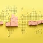 A loader loads goods into a truck against the backdrop of a world map.
