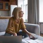 A female homeowner in deep thought while calculating home expenses.