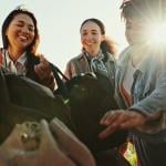 An excited group of friends packing their bags for a roadtrip.