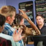 A male cafe worker annoyed at a long line of people waiting to order.