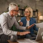 An elderly couple discussing over their estate plan's documents at home. 