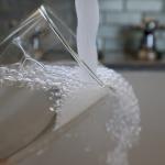 Water running from a kitchen faucet to fill a glass.