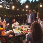 A group of friends laughing together and enjoying their time during a backyard party.