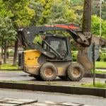 A skid steer loader operating on the park.