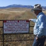 Brad Wilson stands beside a dirt road that leads to a century-old public trail that was abandoned by the U.S. Forest Service as part of a controversial land swap.
