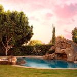 A modern backyard pool with rock waterfalls and slide.