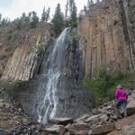 A senior woman at the base of Palisade Falls in Montana.
