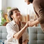 An elderly patient with her caregiver sharing a conversation with each other.