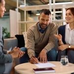 A couple meeting with a financial advisor for an insurance's contract signing.
