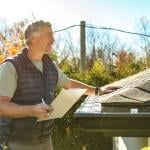 A roofing professional inspects a home's roof.