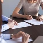 New business partners fill out a document form.