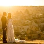 A couple poses for a sunset wedding photograph in their venue in Cappadocia, Turkey.