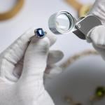 An appraiser inspecting a blue diamond ring.