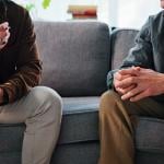 A psychologist discussing evaluation to a patient during a clinic counseling session.