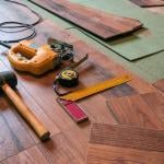 A rubber hammer, an electrofret, and a joiner angle gathered on a laminated floor.