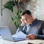 A young adult reviewing an official loan document for personal finance matters.